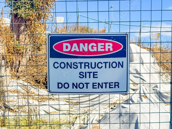 Fototapeta Photograph of a Danger Warning Sign on a fence barricade notifying people not to enter a small construction site in regional New South Wales, Australia. 