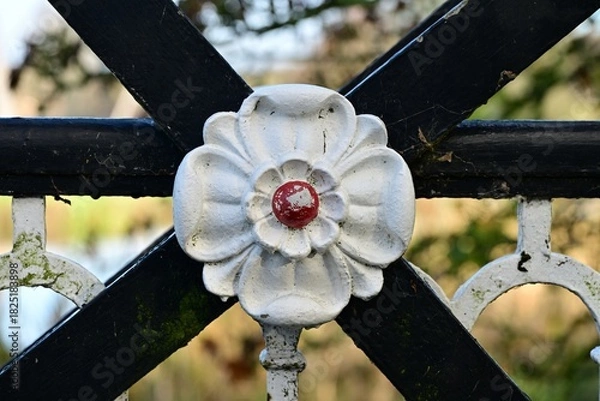 Obraz Decorative Metal Flower on Fence with Red Center and Curves