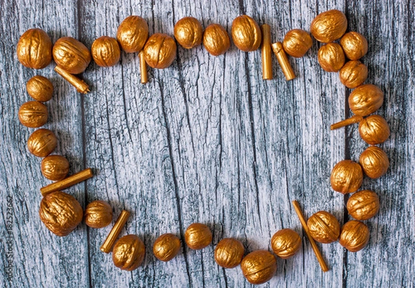 Obraz Gold nuts and gilt sticks on the background of old wooden panels, Christmas and New year background