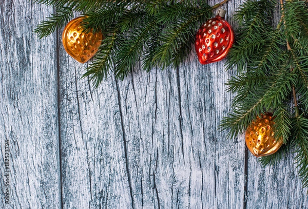 Obraz Branches of spruce with Christmas decorations on a background of old wooden panels, Christmas and New year background