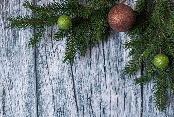Obraz Branches of spruce with Christmas decorations on a background of old wooden panels, Christmas and New year background