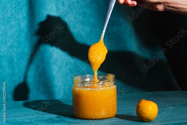 Obraz Spoon scooping homemade fruit jam from jar