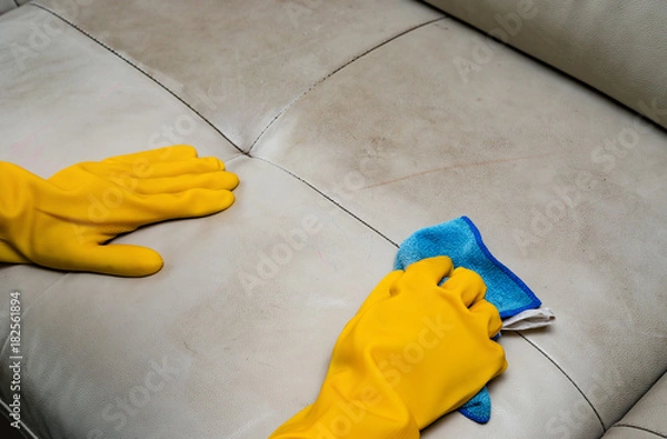 Obraz cleaning leather sofa at home with wet towel