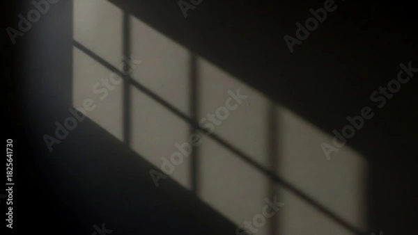 Fototapeta A stark, minimalist composition featuring the shadow of a window cast upon a wall, creating geometric shapes.