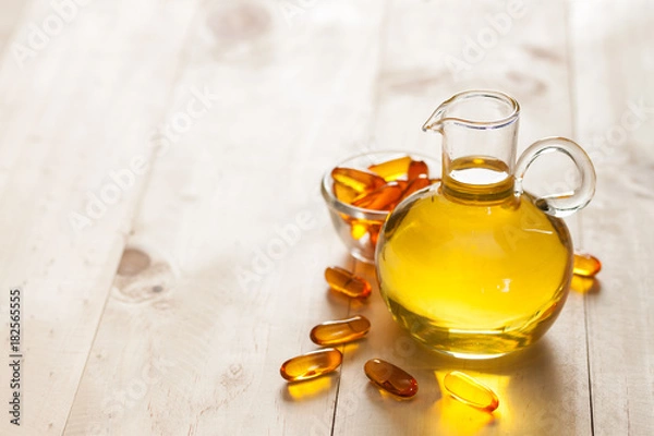 Obraz Fish oil in a jug and capsules on wooden texture and table