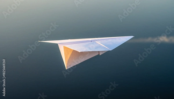 Fototapeta Paper airplane flying through the air with a trail behind it.