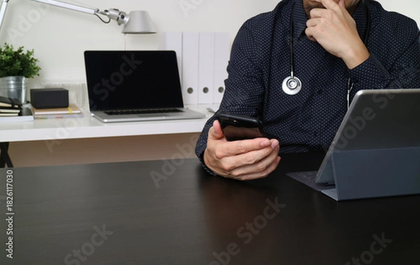 Obraz Doctor Using Smartphone and Tablet in Modern Office