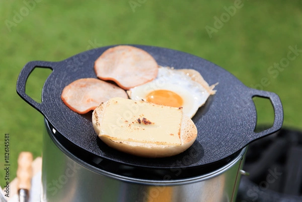 Obraz 黒いマルチグリドルと具材のクローズアップ、芝生の緑を背景に