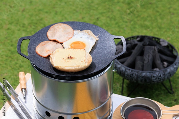 Obraz 黒いマルチグリドルと具材のクローズアップ、芝生の緑を背景に