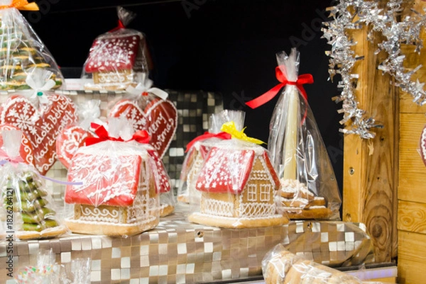 Fototapeta A charming display of decorated gingerbread houses and heart-shaped Christmas cookies.