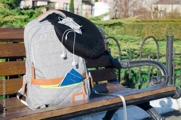 Fototapeta Backpack with Travel Essentials on Train Station Platform Bench