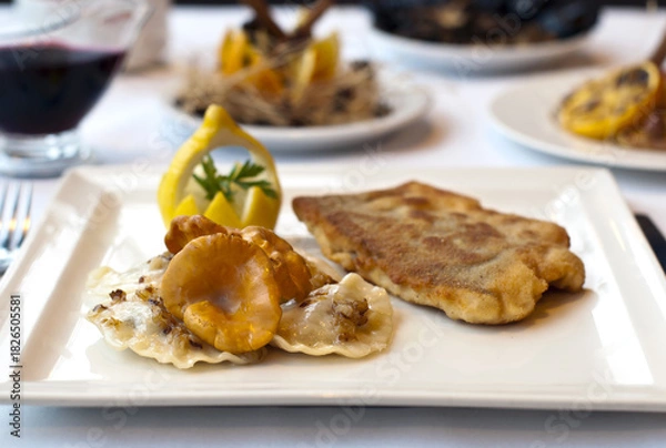 Fototapeta Christmas fried fish in breadcrumbs with chanterelle mushrooms and dumplings