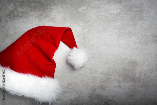 Obraz Red santa hat on a gray concrete table