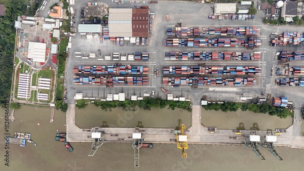 Obraz A large area of land with many buildings and a large body of water. The water is filled with boats and ships