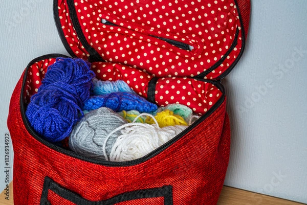 Fototapeta Colourful balls of wool in a red spotted knitting bag, hobby concept