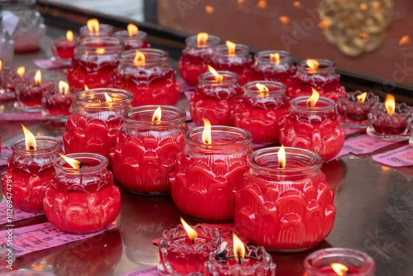 Obraz Red candle jar votive with flame, ritual offering and warm glow creating peaceful atmosphere