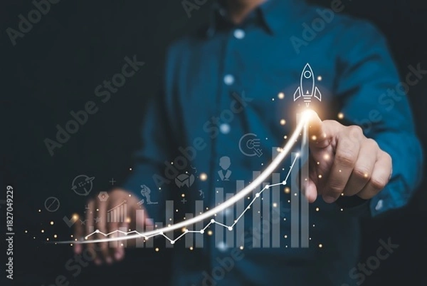 Fototapeta Businessman pointing at a glowing upward trending financial graph