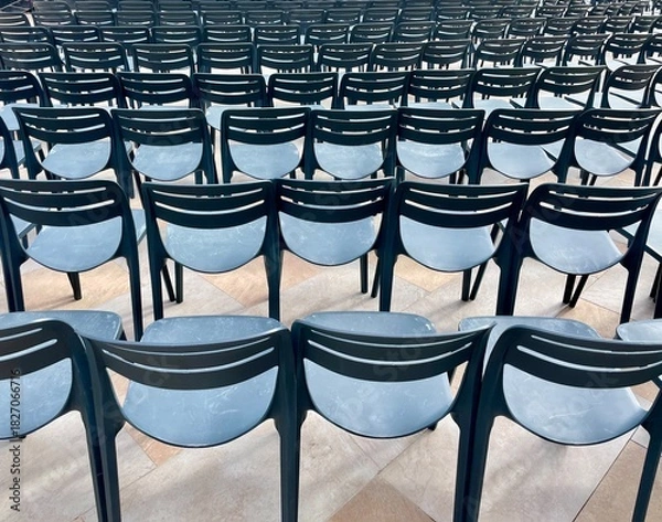 Obraz Rows of empty plastic chairs arranged in a neat formation
