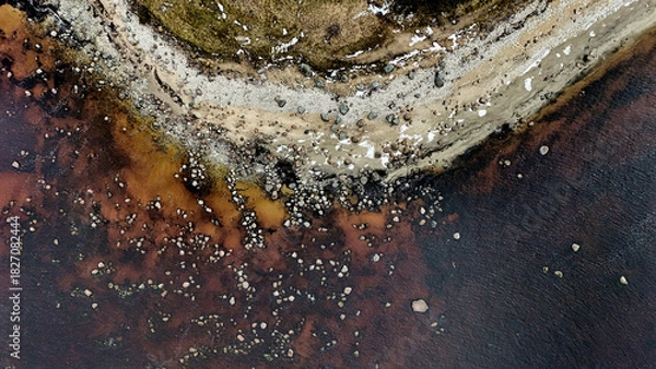 Fototapeta Abstract Aerial Top-Down View of Rocky Shoreline and Dark Water