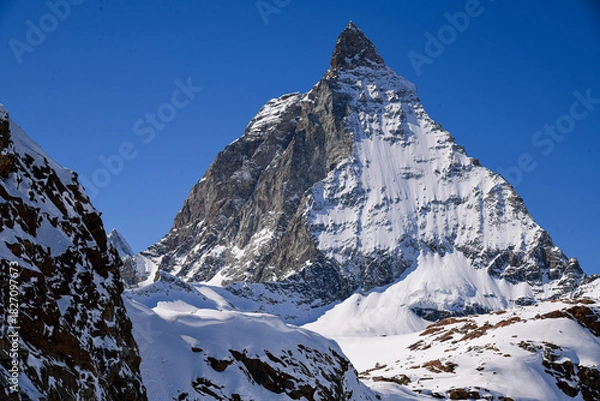 Obraz Close view of the Matterhorn covered in winter snow, rising sharply under a deep blue sky. Iconic Swiss alpine landscape with dramatic textures and prisitine mountain scenery.