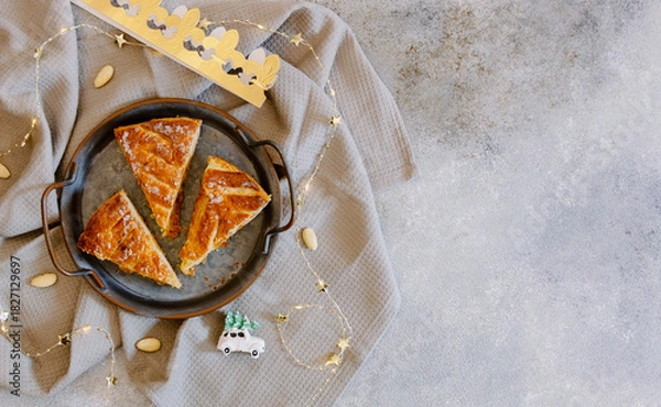 Fototapeta Three pieces of galette on a rustic metal plate on the table.