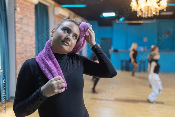 Obraz Participants enjoy a dance class while one dancer takes a break in a studio