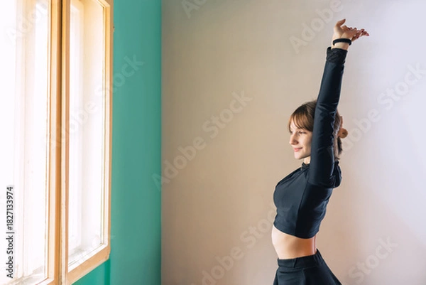Obraz Young women stretching in a bright studio before dance class