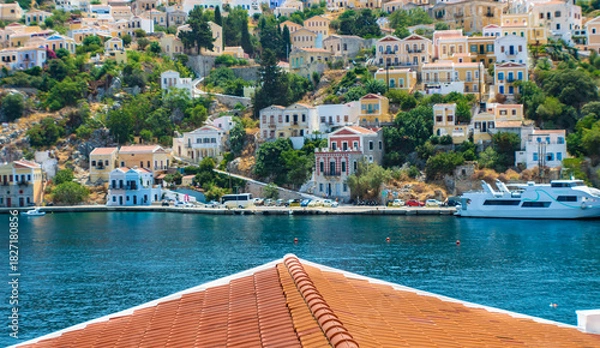 Obraz Landscape view on the colorful neoclassical houses and the sea over the roof from the hill, Symi town, Greece