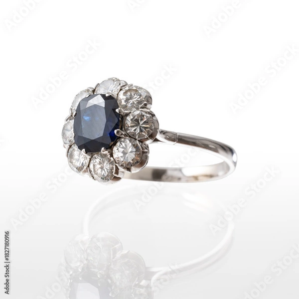 Fototapeta 18kt white gold ring with central sapphire and brilliant-cut diamonds, photographed on a white background with reflection