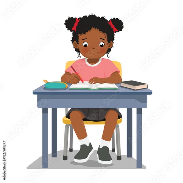 Obraz Little African girl studying sitting at the desk writing on notebook 