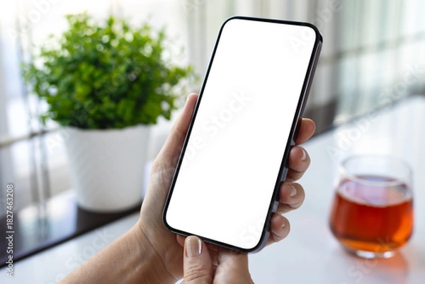 Obraz Female hand holding phone with isolated screen glass of juice