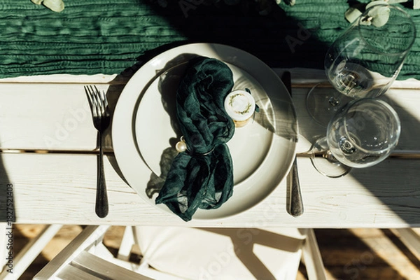 Fototapeta Elegant festive table setting with green decor and glassware