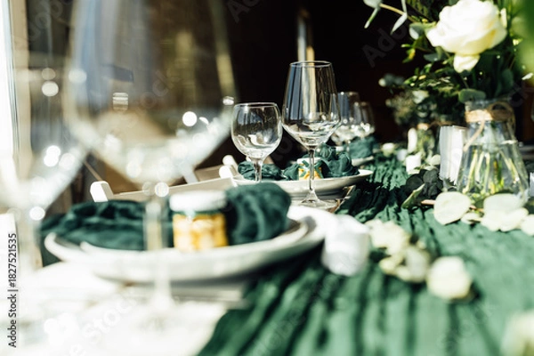 Fototapeta Elegant festive table setting with green decor and glassware