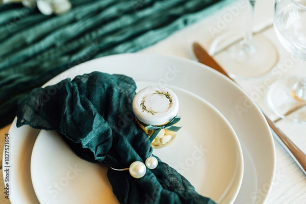 Fototapeta Elegant festive table setting with green decor and glassware