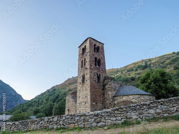 Fototapeta Old stone church nestled in a lush green Pyrenees mountain valley at twilight