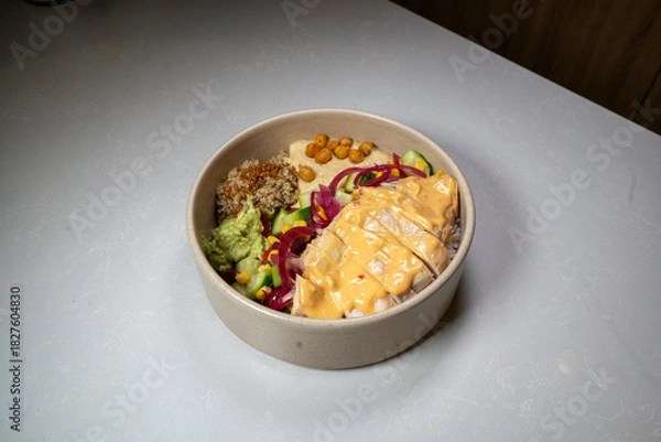 Fototapeta Fresh chicken bowl served with vegetables and grains in a clean, colorful presentation.
