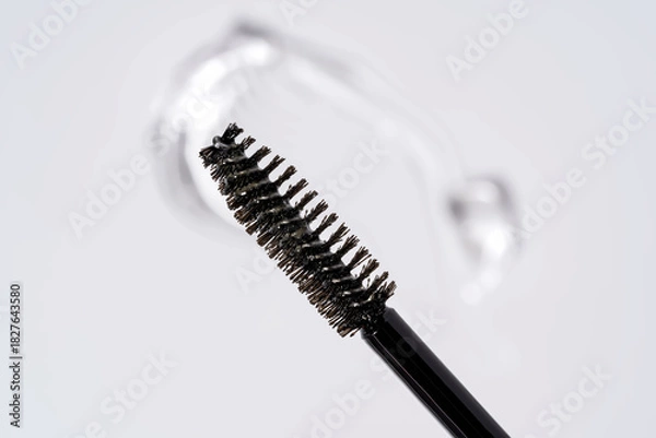 Fototapeta Essence serum gel stroke for eyebrows and eyelashes on a white background next to brush
