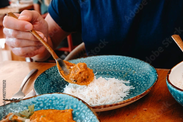 Obraz a man adding tikka masala to his rice