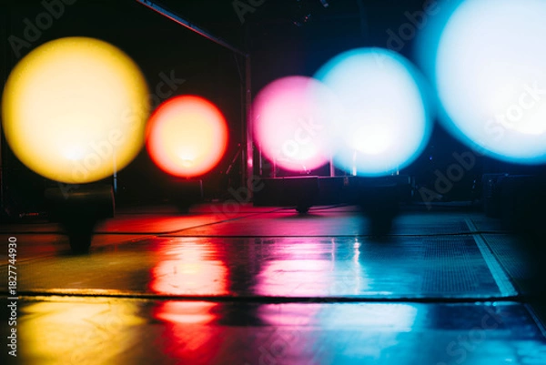 Fototapeta Blurred colorful glowing lights reflecting on a wet surface at night