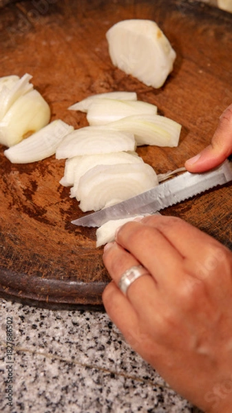 Fototapeta chopping onions on a wooden board