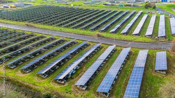 Fototapeta Solar photovoltaic panels from a 3/4 view from the side showing the stands holding them up at a Solar Farm in the West Midlands, UK