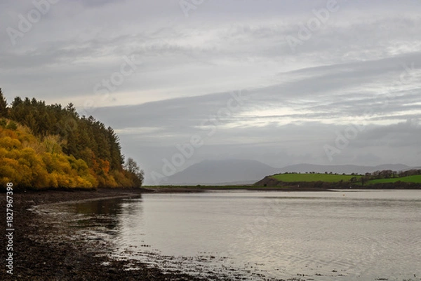 Fototapeta A tranquil autumn landscape near the sea at low tide with a view of the mountains