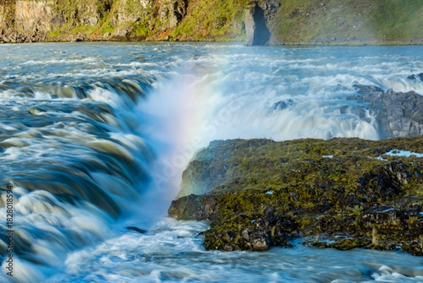 Fototapeta Morning light creates a magical rainbow in the powerful churning flow of a big river in Iceland
