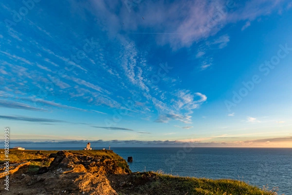 Fototapeta Stunningly beautiful sunset over the ocean as seen from the cape cliffs near the lighthouse of Vik, small city in Southern Iceland, travel tourist destination and sightseeing