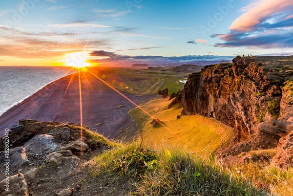 Fototapeta Stunningly beautiful sunset over the ocean as seen from the cape cliffs near the lighthouse of Vik, small city in Southern Iceland, travel tourist destination and sightseeing