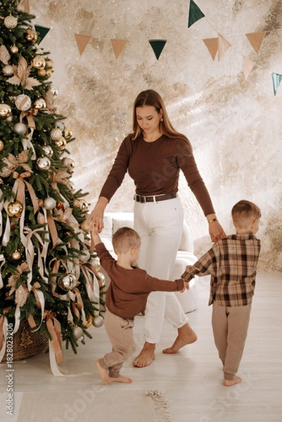 Fototapeta New Year, family, mother and children dancing around the Christmas tree, preparing for the New Year, waiting for the holiday, family New Year photo