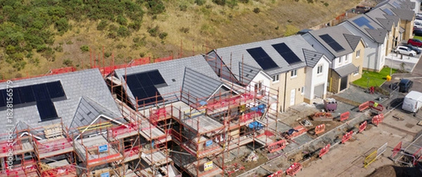 Fototapeta Solar panels installed on home roofs at new housing development