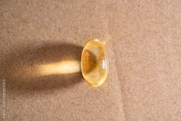 Obraz Omega 3 translucent capsule tablet on a solid surface.
