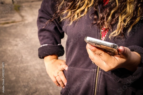 Obraz Woman using smartphone outdoors in casual jacket