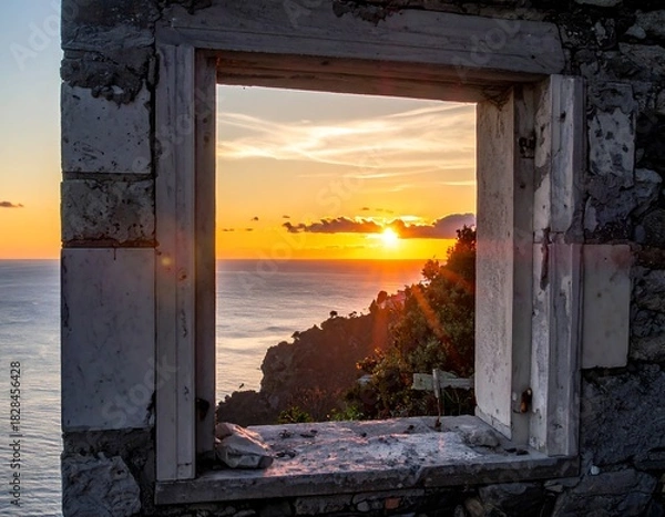 Fototapeta Sunrise over ocean framed by broken stone window. Sunset with vibrant sky and cliffs